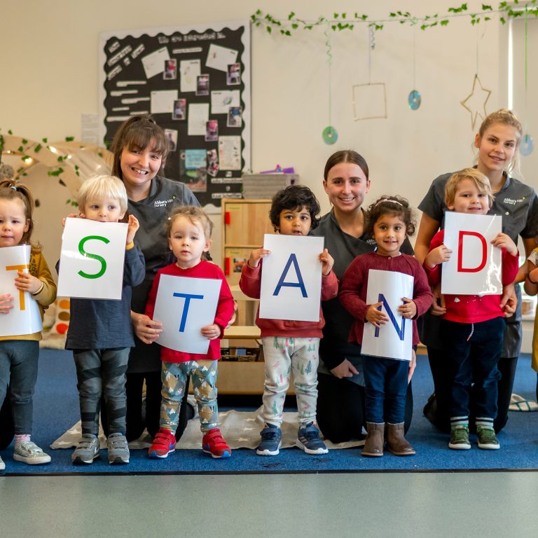 children holding the word "stand"