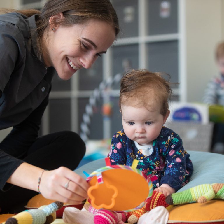 nursery teacher taking care of a baby