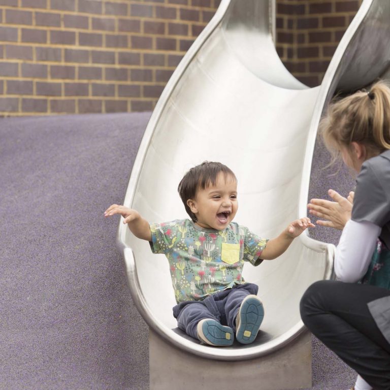 smiling boy coming down a slide