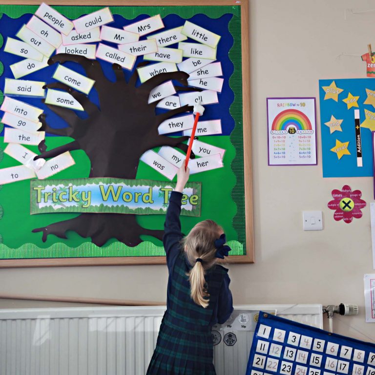 student pointing at a display on the wall