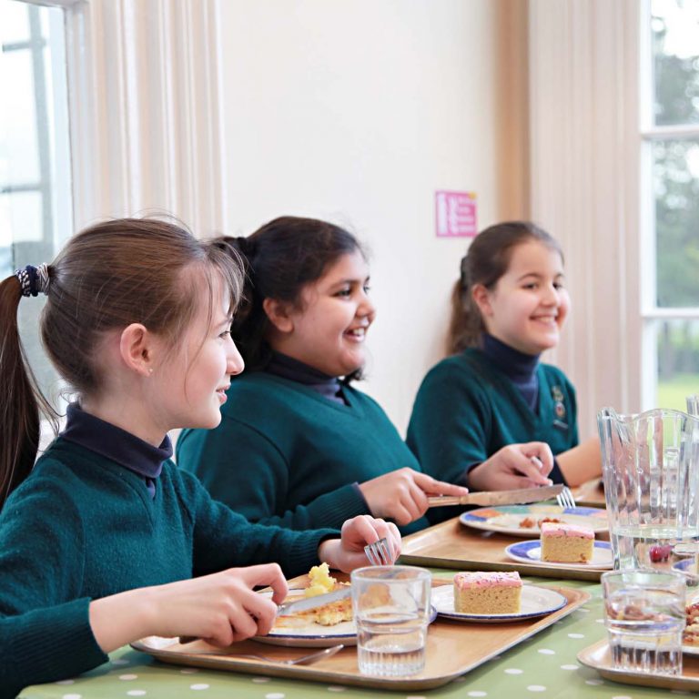 children with plates of food on their table