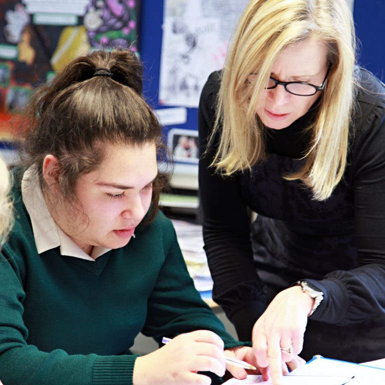 teacher helping a pupil with her work