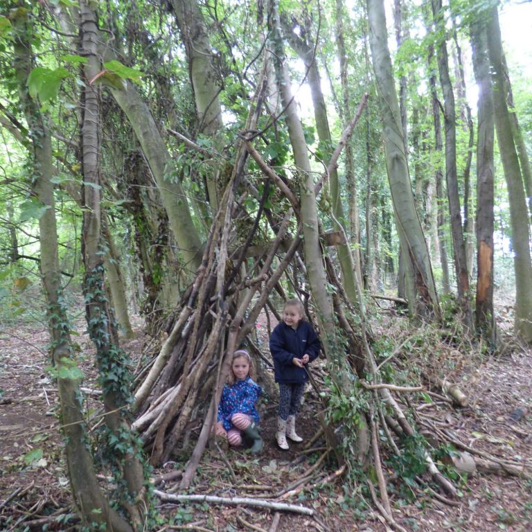 children stood under a hut